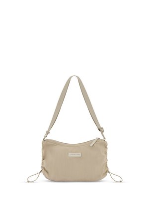 Beige schoudertas met een geribbelde textuur, verstelbare riem, ritssluiting, zijkanten met trekkoord en een klein rechthoekig merklabel aan de voorkant.