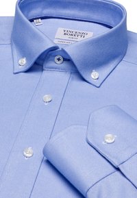 Camicia azzurra chiara, slim-fit, con bottoni e realizzata in tessuto testurizzato. Presenta un colletto aperto e bottoni bianchi. Etichetta visibile all'interno del colletto.
