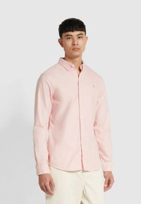 Camicia a maniche lunghe rosa chiaro con colletto alla francese e logo ricamato sul petto; il tessuto è liscio con una leggera lucentezza.