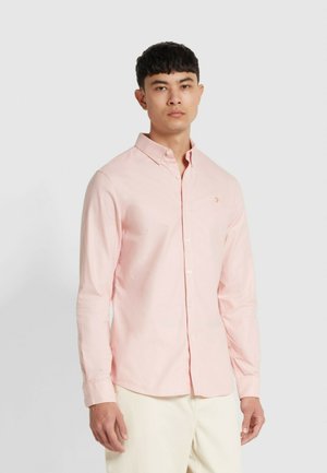 Lichtroze langemouwen shirt met een button-down kraag en geborduurd logo op de borst; de stof is glad met een subtiele glans.