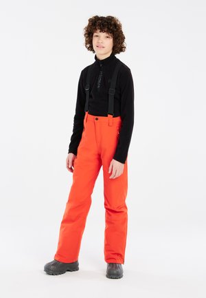 Pantalons de neige orange vif avec des bretelles noires réglables, des poches latérales et une texture lisse, associés à une veste noire zippée.