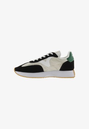 Sneakers met een zwart-wit kleurenschema, voorzien van een gewatteerde bovenkant, suède accenten, een groene hielpatch en een textuur gumzool.