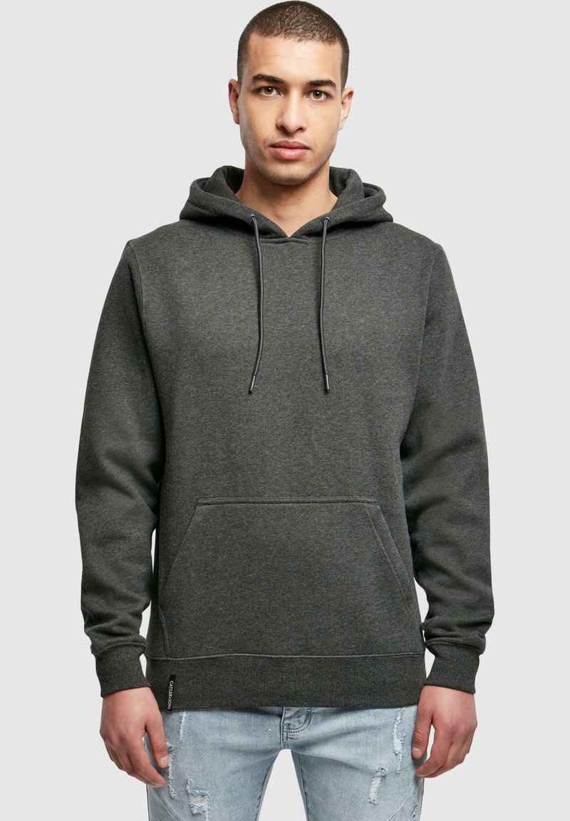 Grauer Kapuzenpullover mit Kängurutasche, Kordelzugkapuze, gerippten Bündchen und Saum. Weicher Stoff mit strukturiertem Finish. Getragen mit hellblauen, ausgewaschenen Jeans.