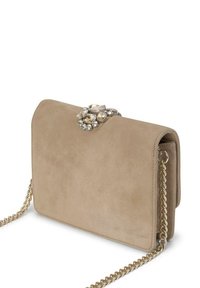 Bolso de ante beige con una correa de cadena dorada y un cierre decorativo adornado con gemas en la solapa, que presenta una textura suave y una forma estructurada.