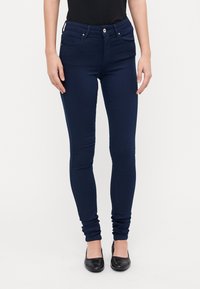 Mørkeblå skinny jeans med høy midje, to frontlommer og sølvfarget knappe-lukking. Glatt, elastisk stoff med tettsittende passform.