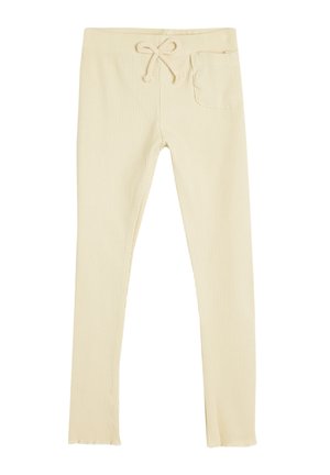 Leggings côtelés beige clair avec taille à cordon, dotés d'une poche latérale et d'une coupe ajustée. Le matériau semble extensible et doux.