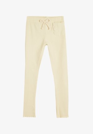 Vaaleanbeige ribbipinnalla varustetut legginssit, joissa on narulla säädettävä vyötärö, sivutasku ja tiukka malli. Materiaali vaikuttaa joustavalta ja pehmeältä.