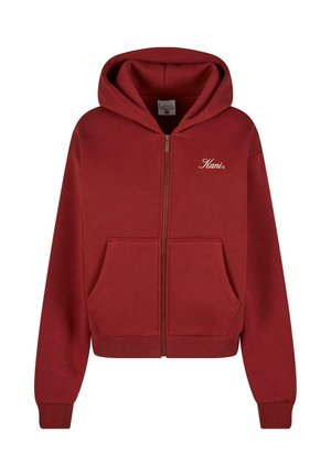 Sarkans kapucis džemperis ar rāvējslēdzēju, izgatavots no mīksta auduma, ar priekšējo kabatu, ribotiem piedurkņu galiem un izšūtu logo uz krūšu.