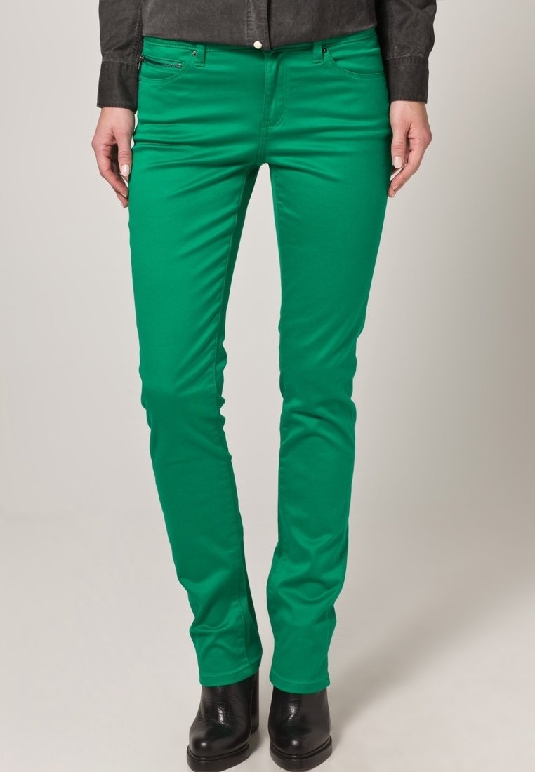 Groene stretchdenim jeans met een slim fit, voorzien van voorzakken en een ritssluiting, gecombineerd met zwarte enkellaarsjes.