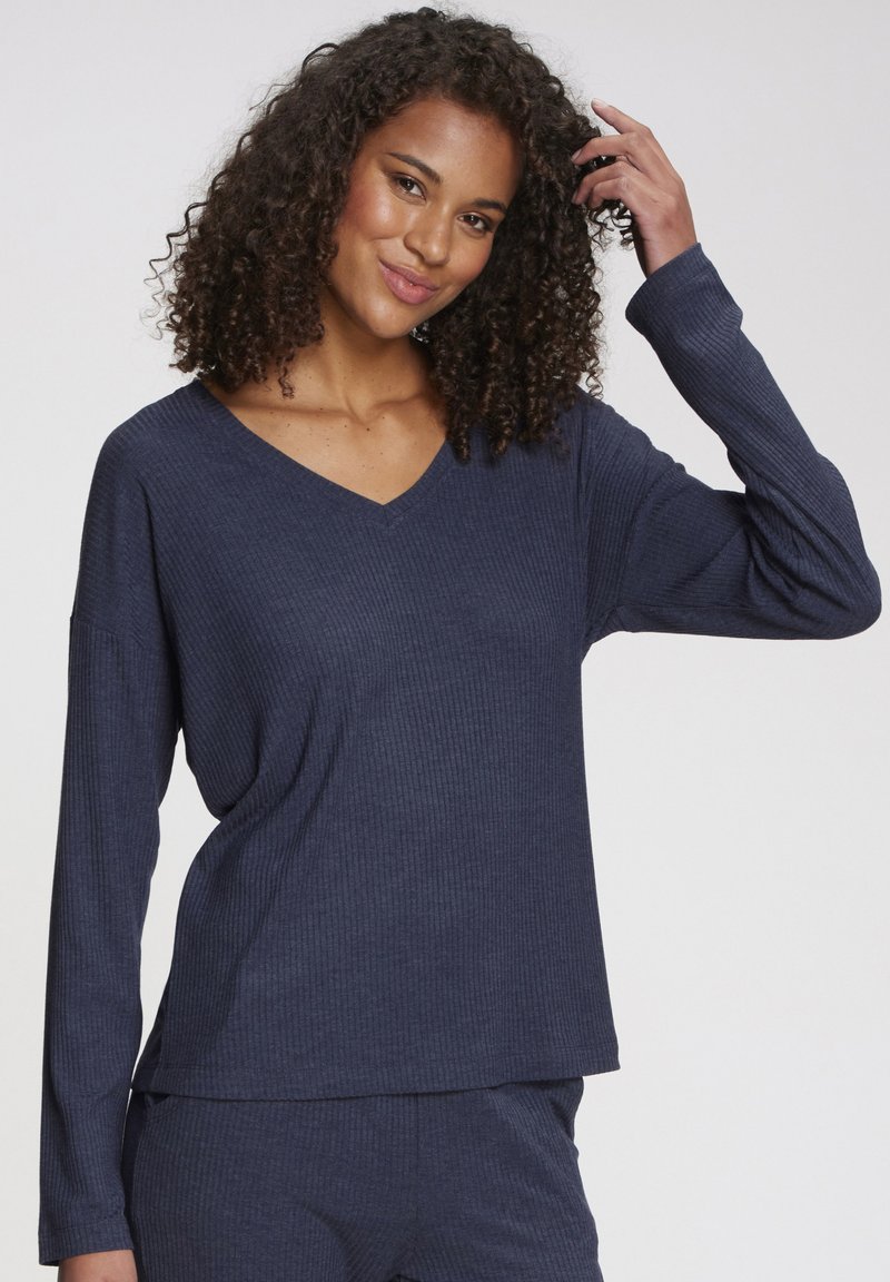 Navy blue long-sleeve top with a V-neck, made of ribbed fabric. Features a relaxed fit and subtle texture.