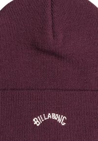 Berretto in maglia bordeaux con texture a coste, caratterizzato da un logo "Billabong" ricamato in bianco sulla parte frontale. Corono che si restringe verso la parte superiore.