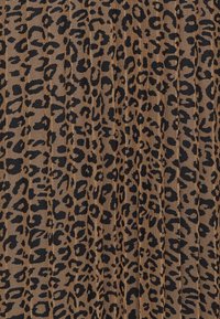 Tela de estampado de leopardo con un fondo marrón claro y manchas negras. La textura parece tejida con detalles de patrón distintos en toda su superficie.