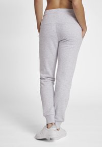 Ljusgrå sweatshirtbyxor med smal passform, elastisk midja och sidofickor. Tillverkade av mjukt bomullsblandat tyg, lämpliga för avslappnad användning.