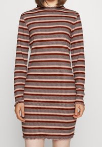 Šaty s dlouhým rukávem v horizontálních pruzích červené, růžové a černé barvy. Žebrovaná textura s vlnkovaným lemem a manžetami.