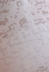 Przezroczysta tkanina o jasnobeżowym i białym abstrakcyjnym wzorze. Miękka w dotyku z subtelnym, nieregularnym wzorem i lekką przezroczystością.