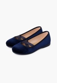 Bailarinas de terciopelo azul marino con tiras elásticas entrelazadas, punta redondeada y suela de goma negra. Textura suave y diseño minimalista.