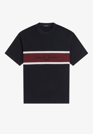 Musta lyhythihainen pyöreäkauluksinen t-paita, jossa on vaakasuorat valkoiset ja viininpunaiset raidat sekä rintakehässä "Fred Perry" -teksti ja laakeriseppelelogo.