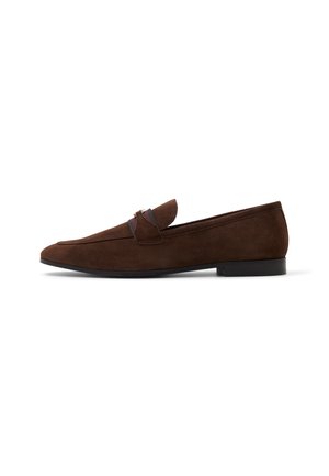 Mocasines de ante marrón con punta redondeada, tacón bajo y una banda decorativa en la parte superior. Textura suave con un mínimo de detalles de costura.