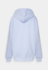 Světle modrá mikina s velkou kapucí, volný střih a žebrovanými manžetami a lemem. Hladká textura s minimálními viditelnými švy.