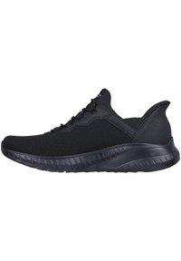 Zapatillas deportivas negras fabricadas con tejido de malla y una superficie lisa y texturizada. Cuentan con una punta redondeada, sistema de cordones y suela de goma con estrías.