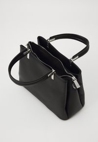 Sac en cuir noir avec deux poignées, zippers en argent et une texture lisse. Dispose d'un intérieur spacieux et ouvert et d'une forme rectangulaire élégante.