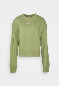 olivově zelený zkrácený svetr s dlouhými rukávy, žebrovanými manžetami a malým bílým logem Nike na hrudi. Vyrobeno z měkké, strukturované tkaniny.