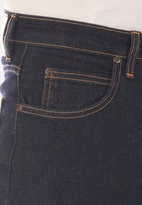 Donkerblauwe denim jeans met oranje stiksels, met een slim fit, voorzak en koperen klinknagels nabij de tailleband en zak.