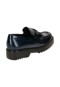 Zwarte gepatineerde leren instappers met dikke, geribbelde zool en een decoratieve gesp, in een schuine weergave die de achterkant en zijkant toont.