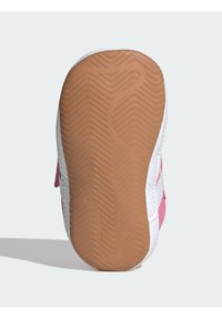 Sportovní obuv se svrškem z růžové semišové kůže, bílými akcenty a prostou jednou texturovaných hnědým gumovým podešvem; obsahuje cik-cak vzor pro lepší přilnavost.