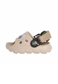 Bežna plastična sandal s ventilacijskim otvorima, podesivim zelenim remenom, crnim metalnim dijelovima i dekorativnom naljepnicom s plavim i zelenim uzorkom.