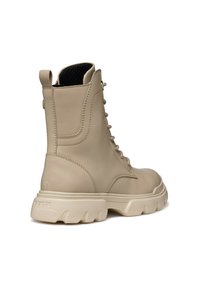 Stivale alla caviglia in pelle beige con finitura texturizzata, suola in gomma robusta e design con lacci. Presenta un'etichetta sul retro.