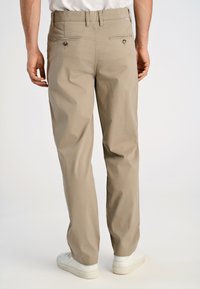 Beige katoenen broek met een rechte pasvorm, voorzien van twee achterzakken met knoopsluitingen en subtiele stikdetails.