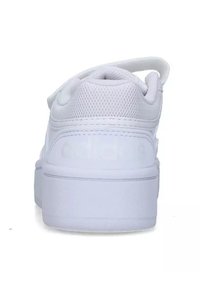 Sneakers bianchi con tomaia in rete testurizzata, suola in gomma liscia e un accento di branding sul retro. Forma arrotondata e design low-top.