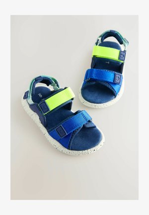 Plave i zelene sandale s podesivim Velcro trakama, mrljasta bijela potplat i mekana tkanina obloga. Dizajn s otvorenim prstima za prozračnost.