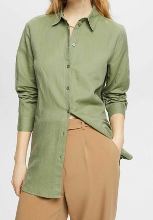Camicia verde a maniche lunghe con colletto, realizzata in tessuto leggero, con chiusura a bottoni davanti e maniche arrotolate.