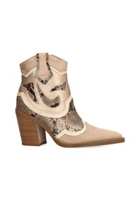 Botas de cowboy color caramelo con acentos de patrón de piel de serpiente, punta afilada y tacón de madera grueso. Presentan una textura de ante y diseños recortados.