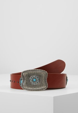 Ceinture en cuir marron avec une boucle en argent ornée de motifs floraux gravés et d'accents en pierre turquoise, présentée sur une surface blanche.