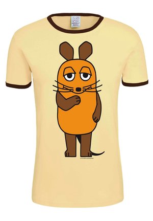 Gele katoenen t-shirt met bruine bies, met een oranje cartoonfiguurtje met een rond lichaam, grote ogen en snorharen. Het figuurtje staat met gekruiste armen.