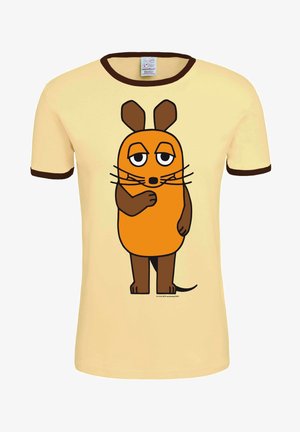 Gele katoenen t-shirt met bruine bies, met een oranje cartoonfiguurtje met een rond lichaam, grote ogen en snorharen. Het figuurtje staat met gekruiste armen.