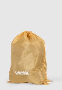 Bolso con cordón en nylon dorado, con textura suave, forma redondeada y logo "SMILODOX" impreso en blanco en el frente.