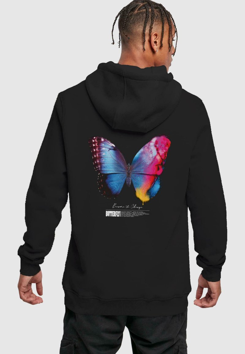 Hoodie noir avec un graphique coloré de papillon dans le dos, avec des teintes de bleu, de rose et de jaune. Texture douce avec une coupe décontractée.