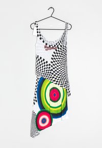 Robe asymétrique avec un haut à carreaux noir et blanc et un motif circulaire multicolore sur la jupe. Fabriquée en tissu léger.