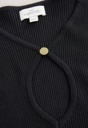 Sort ribbet graviditetstop med rund gylden knaplukning ved halsudskæringen. Stoffet er tekstureret og blødt med en tætsiddende pasform.