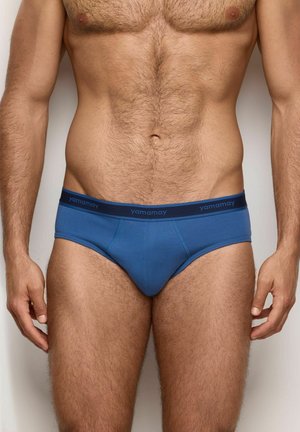 Boxer di cotone blu da uomo con una cintura elastica blu navy che presenta il nome del marchio "yamamay." Progettati con una vestibilità aderente e dettagli di cucitura.
