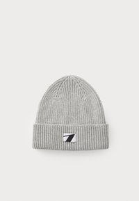 Bonnet en tricot gris avec une texture côtelée et un revers replié, présentant un petit patch logo noir et blanc à l'avant.