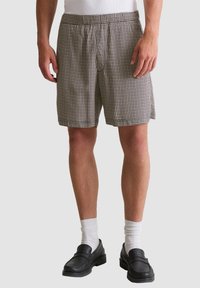 Heren shorts in een geruit patroon, in zwart-witte kleuren, met een elastische tailleband en een losse pasvorm voorcomfort.