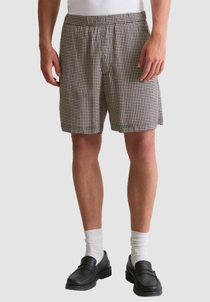 Männer-Shorts im karierter Muster, schwarz-weiße Farben, mit elastischem Bund und lockerer Passform für Komfort.