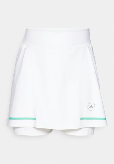 Bela športna krilca z širokim pasom, ki imajo svetlo zeleni poudarek na robu in logo na spodnji strani. Gladka tekstura tkanine.