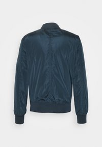 Blå nylon bomberjacka med ribbad krage, manschetter och midja. Har en slät textur och en enkel rygg utan fickor eller dekorationer.