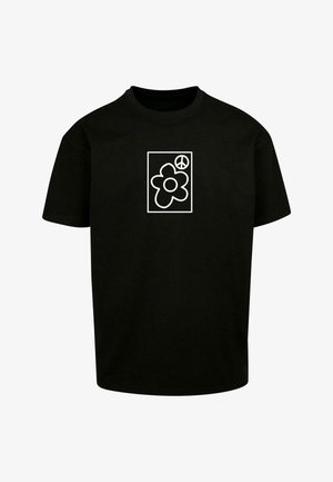 T-shirt nera in cotone con una grafica bianca di un fiore e un simbolo di pace all'interno di un quadrato. Collo rotondo, maniche corte, vestibilità rilassata.